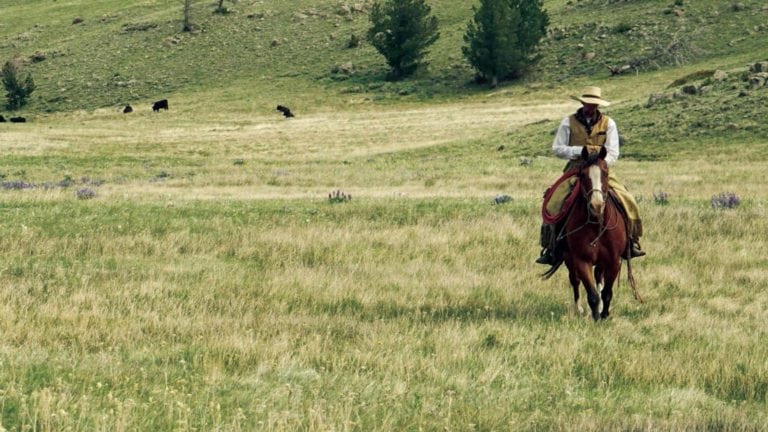 Cowboy riding horse on Chugwater Creek Ranch