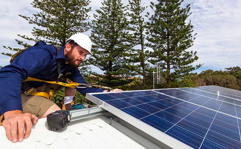 technician installing solar panels on home