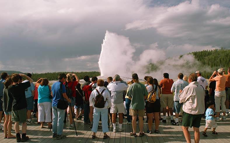 image of crowds watching geyser erupt at Yellowstone National Park