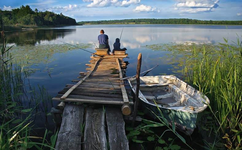 father and son fishing on dock