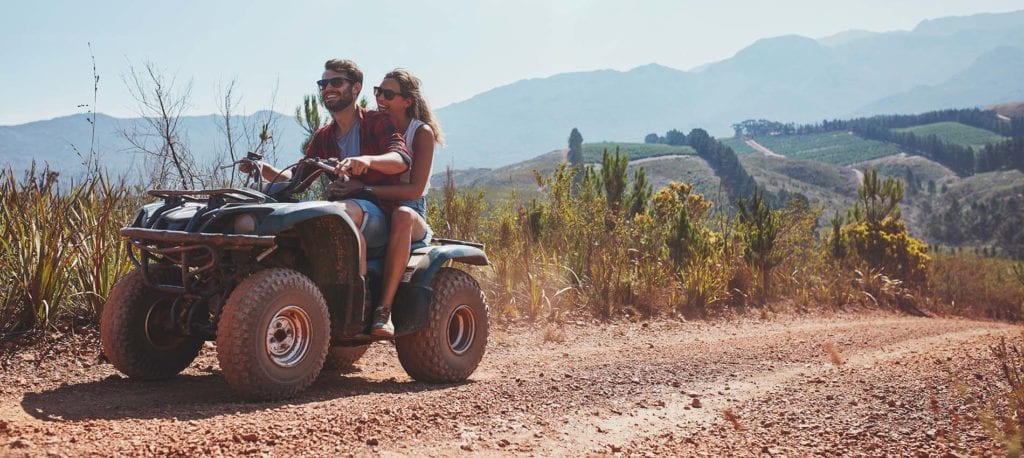 young couple riding quad bike